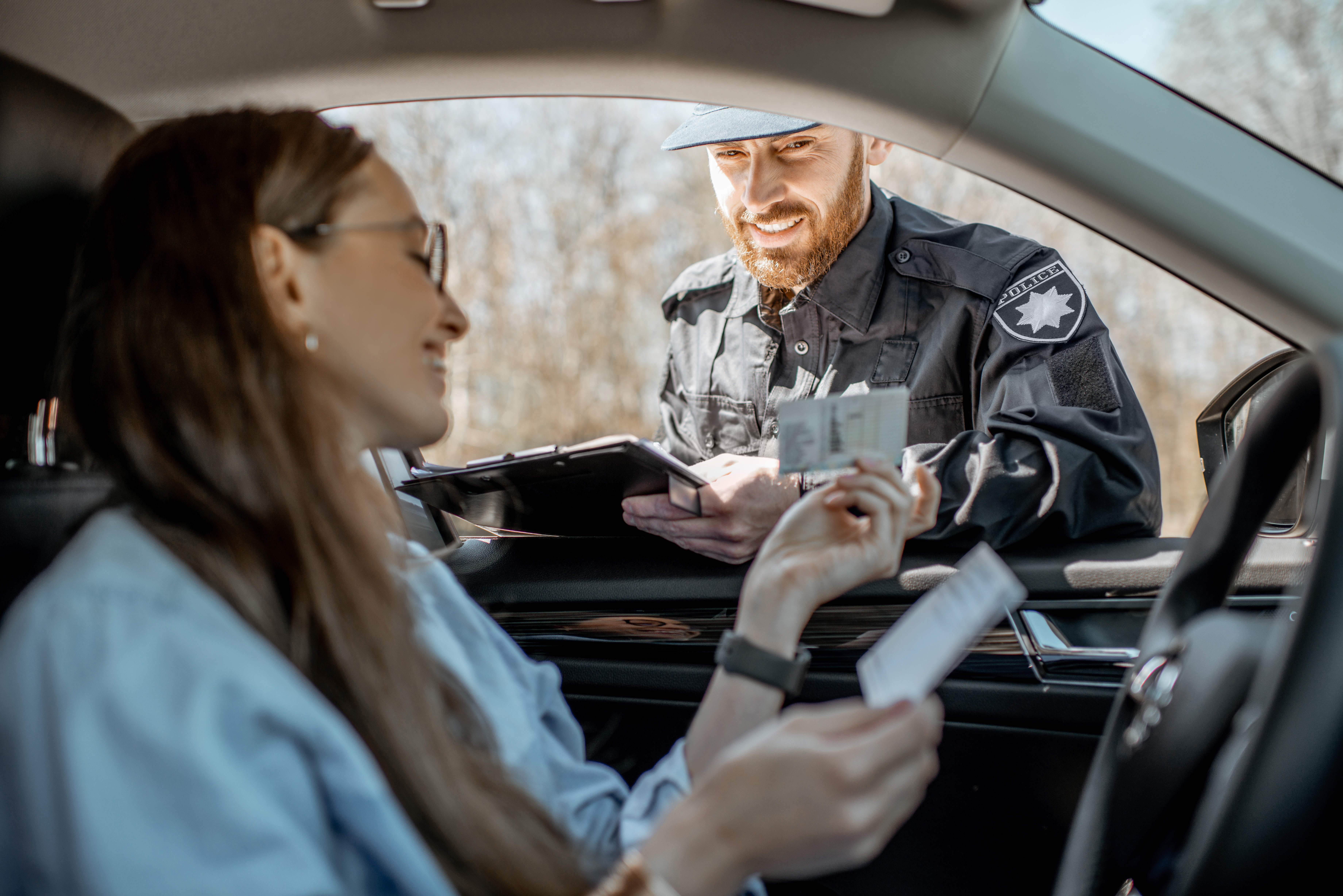 Polizist kontrolliert den Führerschein einer Autofahrerin