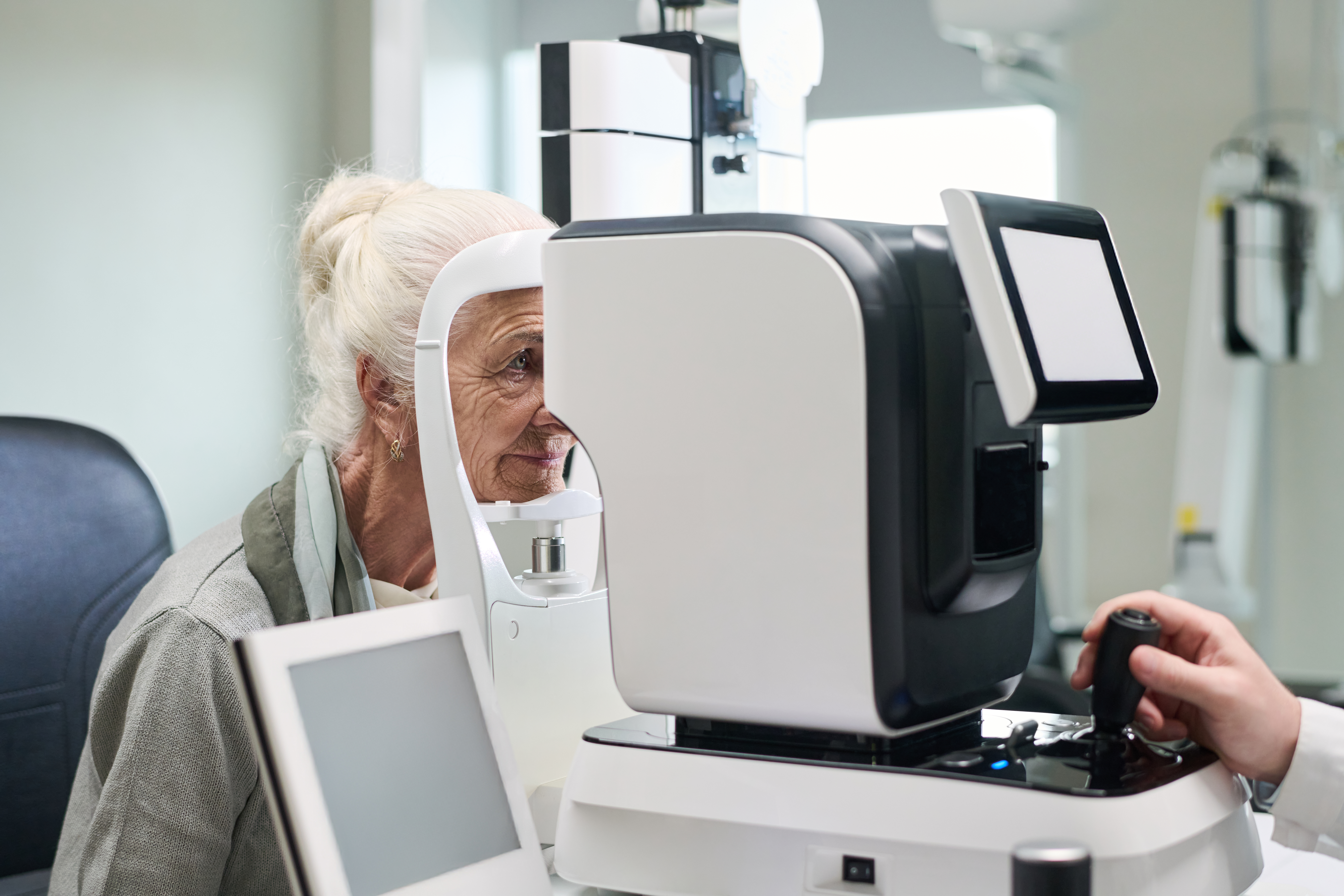 Ältere Patientin bei einer Augenuntersuchung am modernen Diagnostikgerät